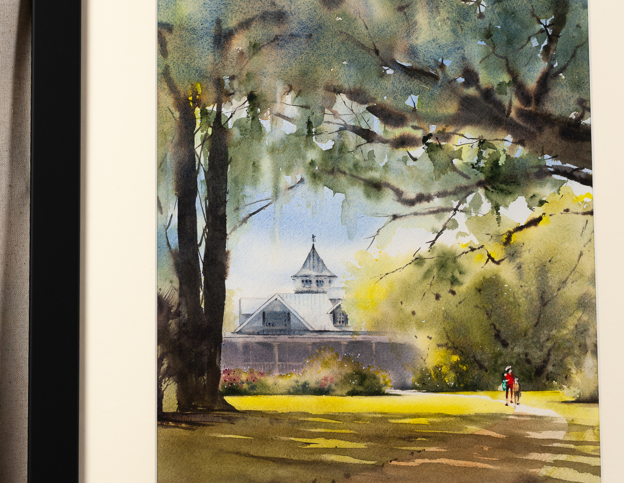 Close-up of framed Magnolia Plantation and Gardens watercolor, showing the historic plantation home beneath live oaks and Spanish moss, with golden sunlight and a garden path in Charleston, South Carolina.