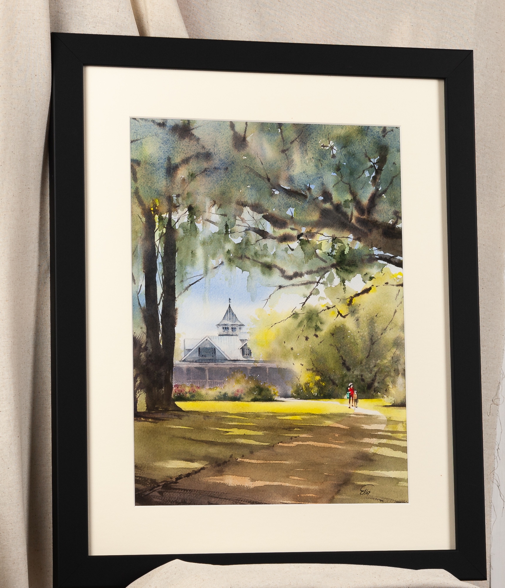 Framed original watercolor painting of Magnolia Plantation and Gardens in Charleston, South Carolina, featuring live oaks, Spanish moss, a historic plantation home, and warm sunlight, displayed with an ivory mat in a black frame.
