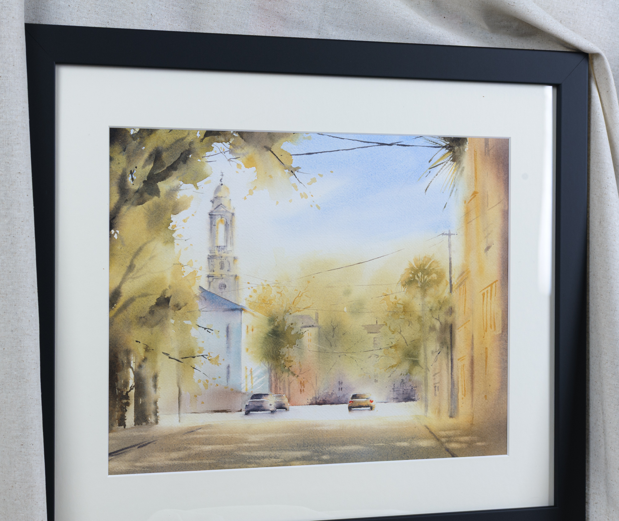 Angled view of framed St. John’s Lutheran Church Charleston watercolor painting with white mat