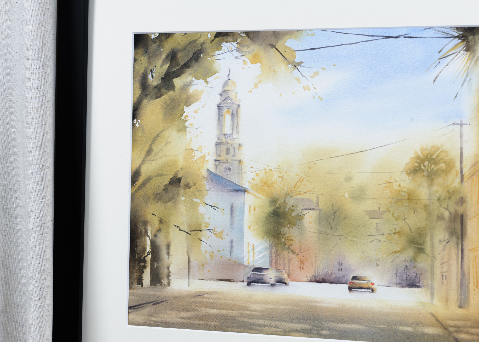 Close-up of framed St. John’s Lutheran Church Charleston watercolor showing the church tower and street